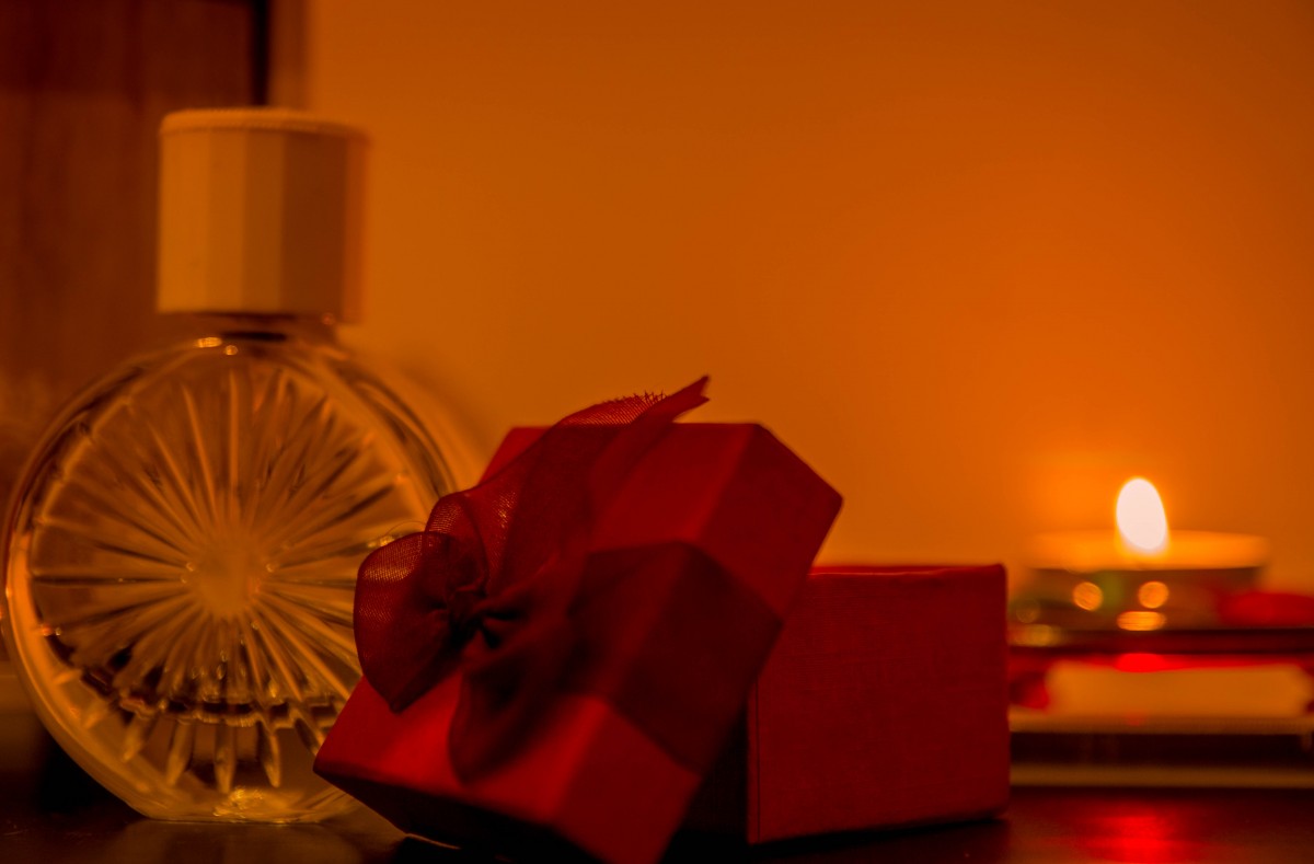 زجاجة عطر مربع مربع أحمر العطر الشريط هدية عيد الميلاد لا يزال التصوير الفوتوغرافي الحياة لا تزال غرفة التصوير الفوتوغرافي الصبغات والظلال